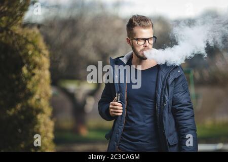 Vaping flavored e-liquid from an electronic cigarette Stock Photo