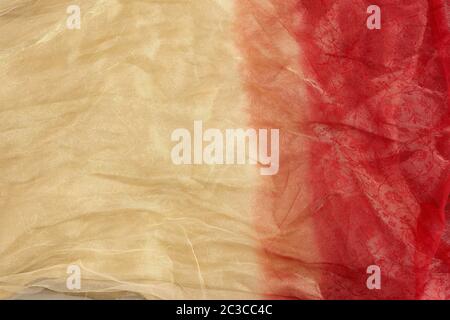 crumpled yellow-red tulle, fabric for sewing clothes, full frame, close up Stock Photo