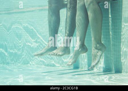 Underwater couple legs in swimming pool Stock Photo