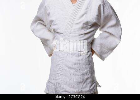 Stages of correct tying of the belt by a teenager on a sports kimono, step three Stock Photo