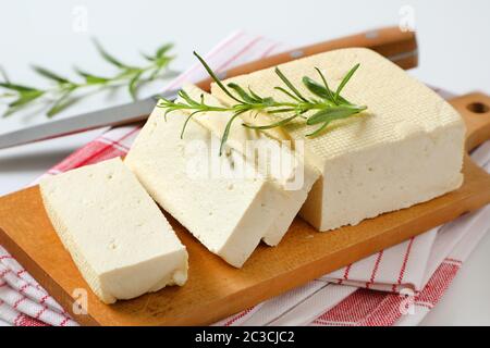 Sliced block of fresh bean curd (tofu) on cutting board Stock Photo