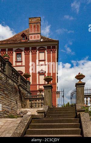 Opocno / Czech Republic - June 16 2020: View of the castle with red and pink facade and stone stairs leading onto the courtyard. Sunny summer day. Stock Photo