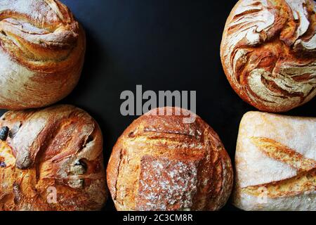 Bread. Assortment of different types of bread on a blackn background. Loaf, bun, baguette, cereal bread. Bakery products. Stock Photo