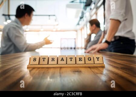 Strategy word on wood table with Business team work discussion together concept in background Stock Photo