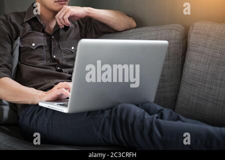 Businessman works on the sofa at home. Work searching for new idea creative and drinking hot coffee feeling think hard. Stock Photo
