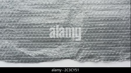 fragment of a transparent film with air for the transportation of parcels is glued on gray polyethylene, inside of the envelope Stock Photo