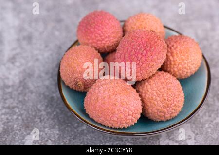 Lychees on a grey textured background Stock Photo
