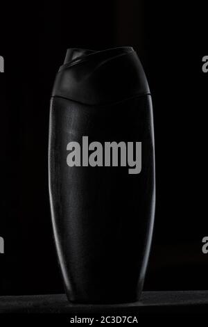 black plastic bottle for shampoo or shower gel on black isolated background Stock Photo