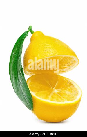 yellow lemon cut into two parts with a leaf isolated on a white background Stock Photo