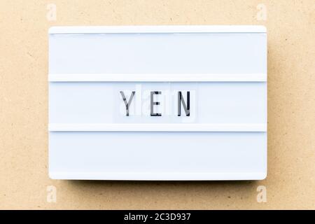 White lightbox with word yen on wood background Stock Photo