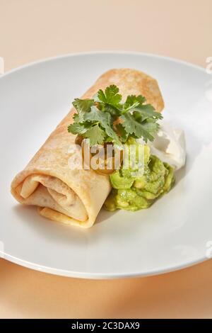 Homemade pancake roll with spicy guacamole and white sauces. Stock Photo