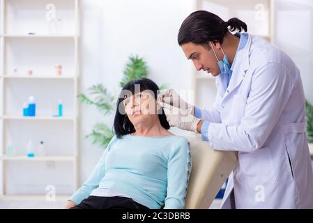 Old woman visiting young doctor laryngologist Stock Photo