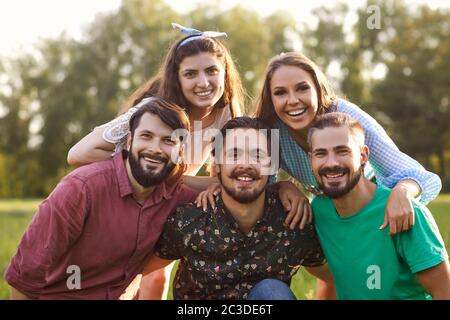 Portrait of young friends having good time in countryside. Group of happy people spending their weekend in nature Stock Photo