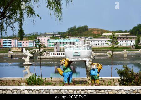 Kaesong, North Korea - May 5, 2019: Funny plaster sculpture of the cartoon characters, pond and residential districts at on background Stock Photo