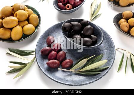 Olives, green, black and red, an assortment with leaves on a white background Stock Photo