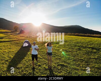 Aerial view of love couple of hikers spend time together away from city bustle by sunrise in camping mountains day Stock Photo