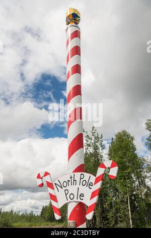 A giant candy stripped pole marking the spot in North Pole, Alaska. North Pole is not actually the geographic northern pole but a Christmas themed town outside Fairbanks. Stock Photo