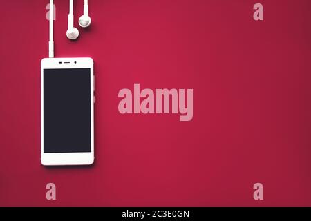 Mock-up smartphone on red background. Flat lay. Copy space. Music concept.Top view Stock Photo