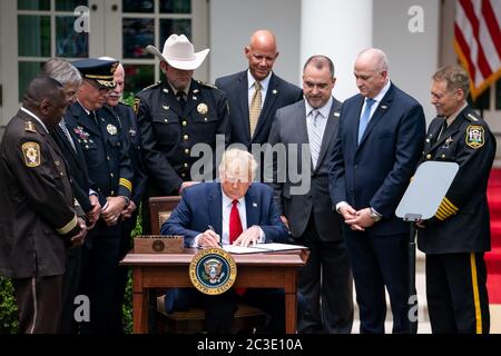 President Donald J. Trump signs an executive order on safe policing for safe communities Tuesday, June 16, 2020, in the Rose Garden of the White House.