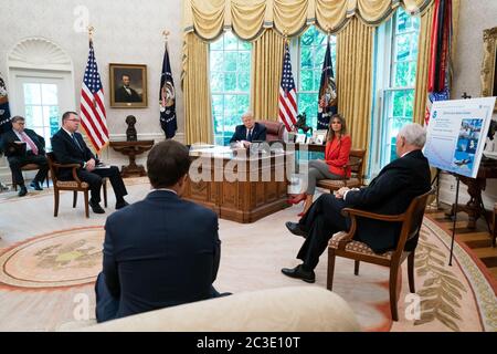 President Donald J. Trump, First Lady Melania Trump, and White House senior advisors listen as Vice President Mike Pence delivers remarks during a briefing on the 2020 hurricane season Thursday, May 28, 2020, in the Oval Office of the White House. Stock Photo