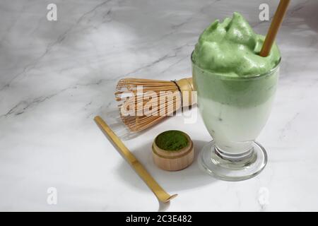 Green matcha dalgona. Trendy hipster drink on marble background. Stock Photo