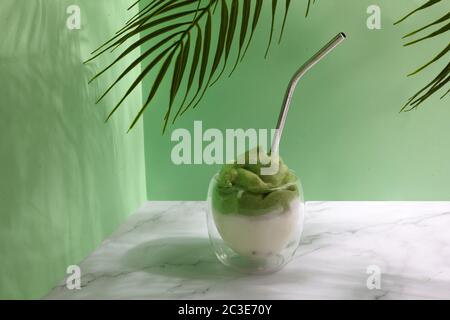 Green matcha dalgona. Trendy hipster drink on marble background. Stock Photo