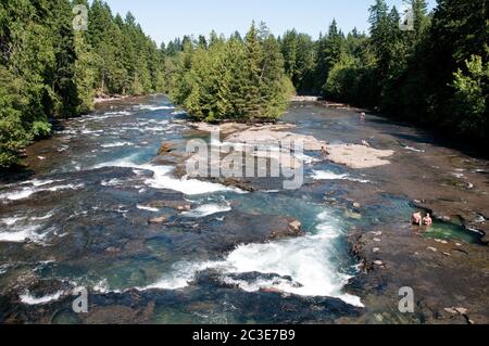 People bathing in rock pools at a place called Medicine Bowls on the Browns River near Courtenay, Vancouver Island, British Columbia, Canada. Stock Photo