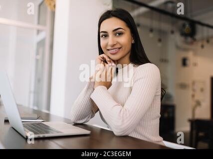 Beautiful Indian woman freelancer using laptop, working from home. Student studying, distance learning, online education concept Stock Photo