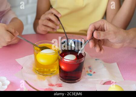 Family dipped chicken eggs in a food coloring solution Stock Photo