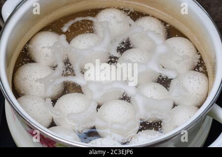 Chicken eggs are boiled in a pan, close-up Stock Photo