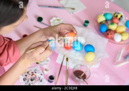Girl paints chicken eggs for Easter Stock Photo