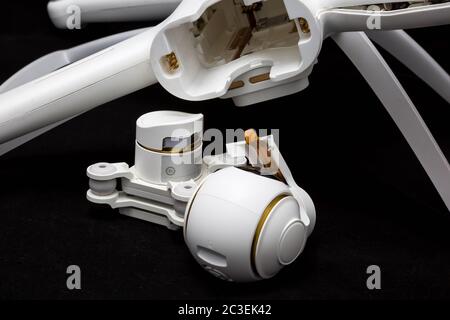 Moscow, Russia - May 13, 2019: Broken white Xiaomi Mi drone 4k after a fall. On a black background. Damaged body and stabilizer camera gimbal. Closeup Stock Photo