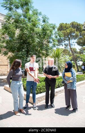 Brother Peter Bray who is the Vice Chancellor of Bethlehem University talking with some of his students on the campus. Stock Photo