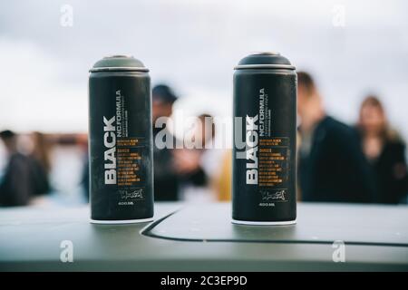 Moscow, Russia - July 06, 2019: Two black cans with Montana paint are standing on the roof of a car. Against the background of people. Spray paint for street art and graffiti Stock Photo