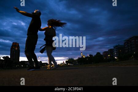 19 June 2020, Hessen, Frankfurt/Main: Vanessa and Lionel are dancing Salsa on the banks of the river Main in Frankfurt's Ostend district after sunset. Photo: Arne Dedert/dpa Stock Photo