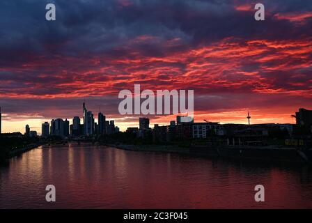 19 June 2020, Hessen, Frankfurt/Main: At sunset, the sky above the Frankfurt skyline and the water of the Main are coloured deep red. Photo: Arne Dedert/dpa Stock Photo