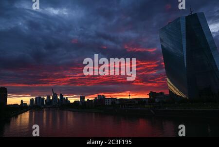 19 June 2020, Hessen, Frankfurt/Main: At sunset, the sky over the Frankfurt skyline and the ECB's Head Office (r) is coloured deep red. Photo: Arne Dedert/dpa Stock Photo