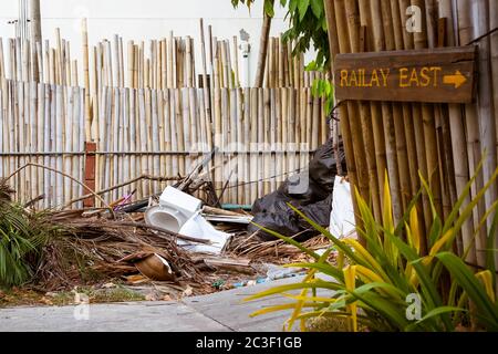 Railay, Krabi Province, Thailand - February 17, 2019: Garbage and other waste on the streets of the Railay Peninsula. The toilet is next to the pedestrian walkway.