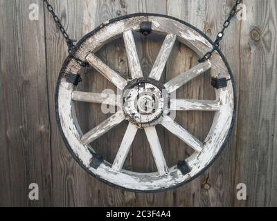 Old wooden cart wheel on a gray wooden wall. High quality photo Stock Photo