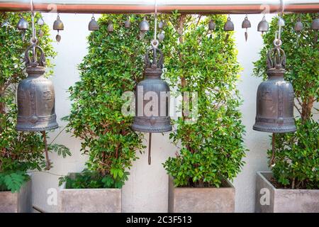 Row of large traditional bells hanging in buddhist temple Stock Photo