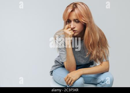 Crying young woman with strawberry blonde hair feels unhappy and depressed, isolated. Problem in relationships, relationships breakup, love depression Stock Photo