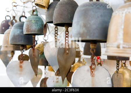 Many small metal bells hanging in Buddhist temple Stock Photo
