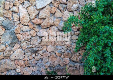 Background of limestone masonry. The surface is decorated with natural material. The wall is made of wild stone. Stock Photo
