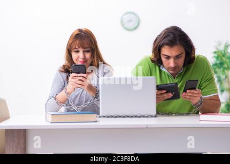 Two students in gadget dependency concept Stock Photo