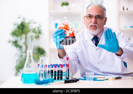 Old male chemist working in the lab Stock Photo
