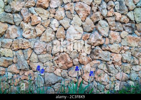 Background of limestone masonry. The surface is decorated with natural material. The wall is made of wild stone. Stock Photo
