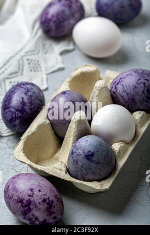Stylish blue and purple Easter eggs in a paper tray. Stock Photo