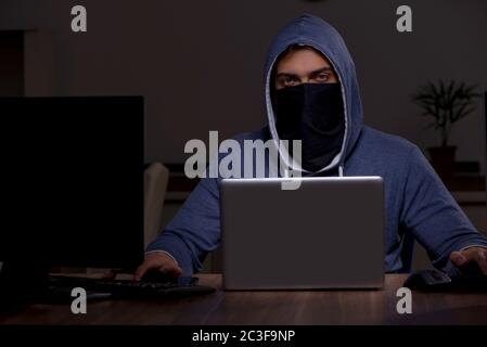 Male hacker hacking security firewall late in office Stock Photo