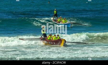 ALEXANDRA HEADLAND, QUEENSLAND, AUSTRALIA- APRIL 22, 2016: two surf boats catching waves at the end of a race Stock Photo