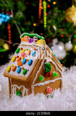 Gingerbread house with round candies and frosting on snow. Stock Photo